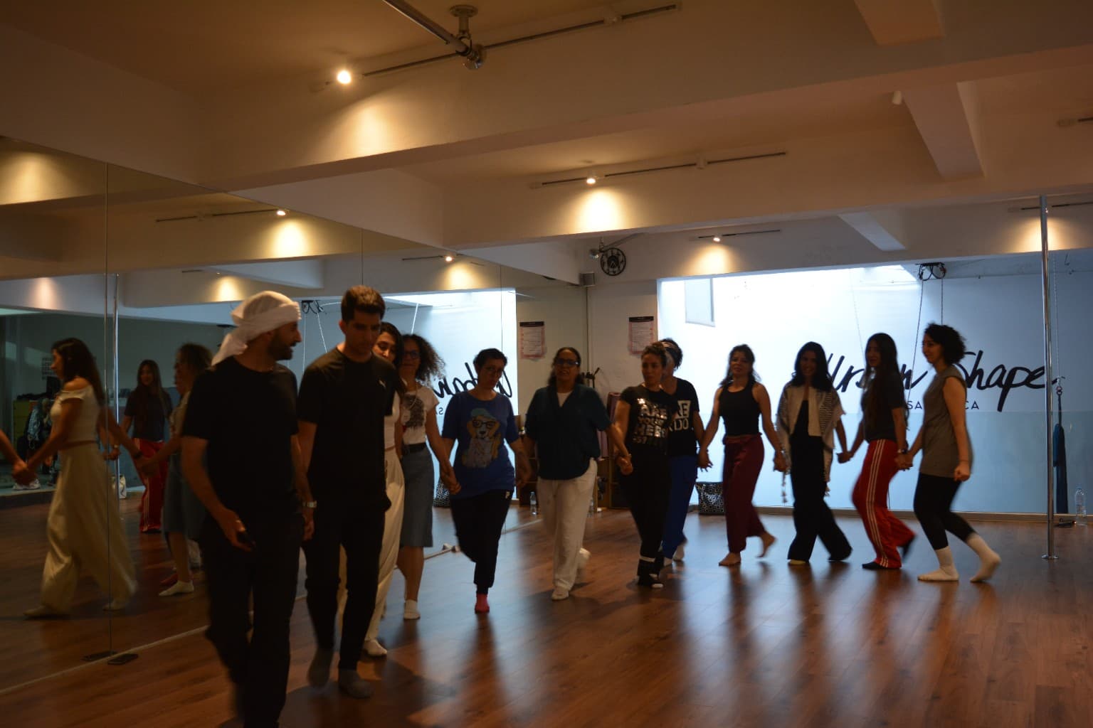 Participants dancing Dabke together in a mirrored studio
