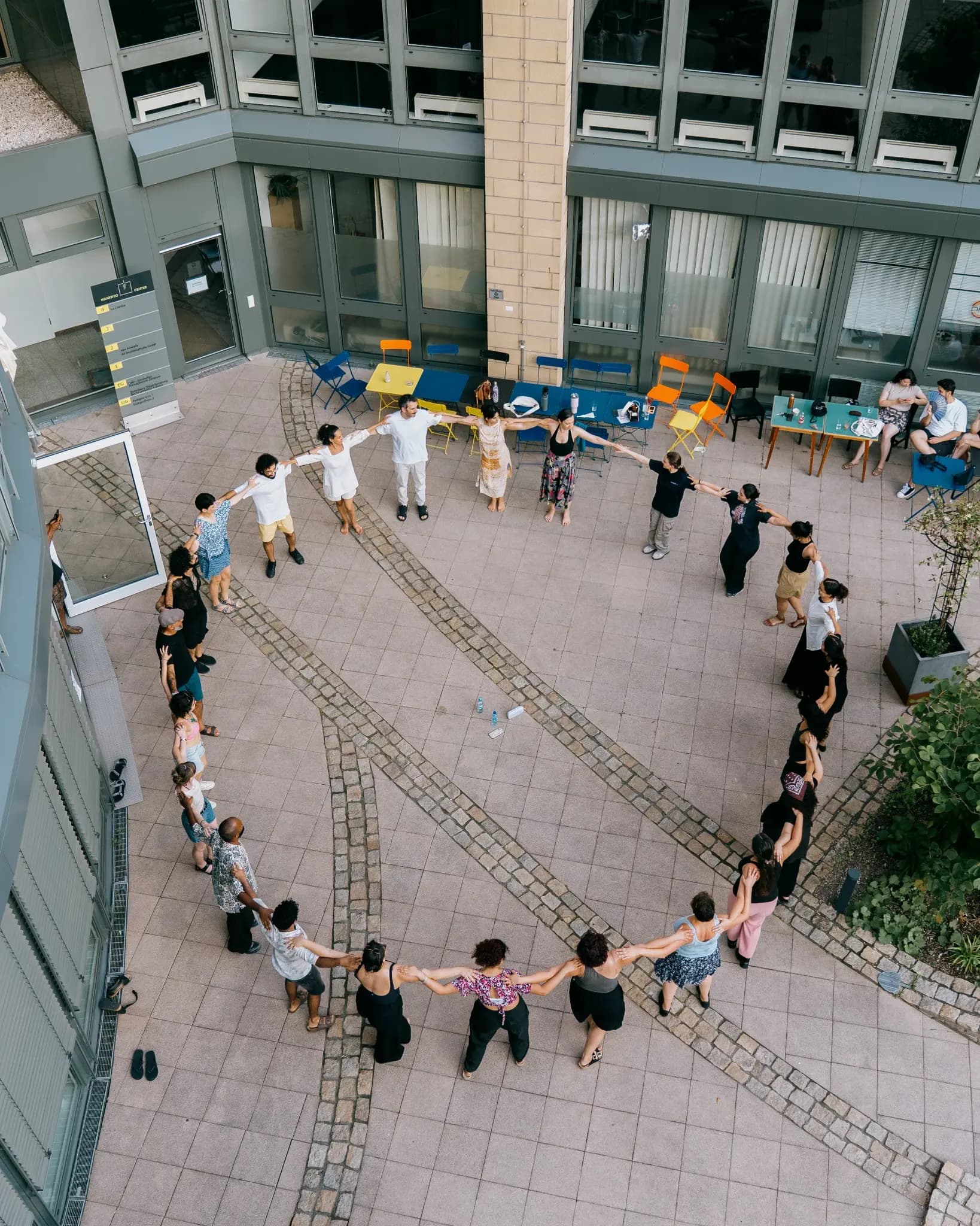 Menschen tanzen gemeinsam Dabke in einem großen Kreis in einem Innenhof
